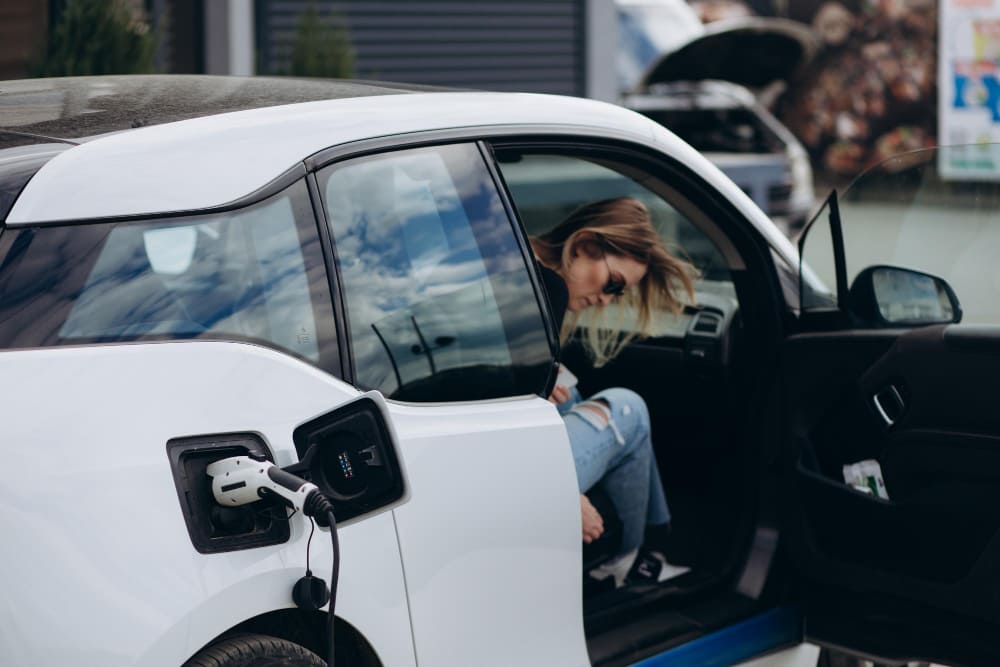 A woman entering an electric car