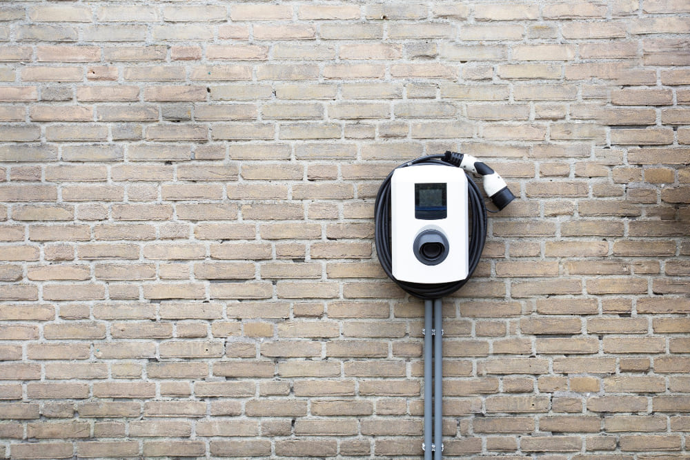 A new charging station for electric car on brick wall at home