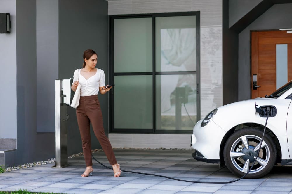 A Woman Charging Her Electric Car at Home